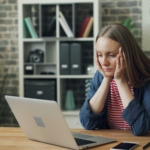 tired woman looking at laptop