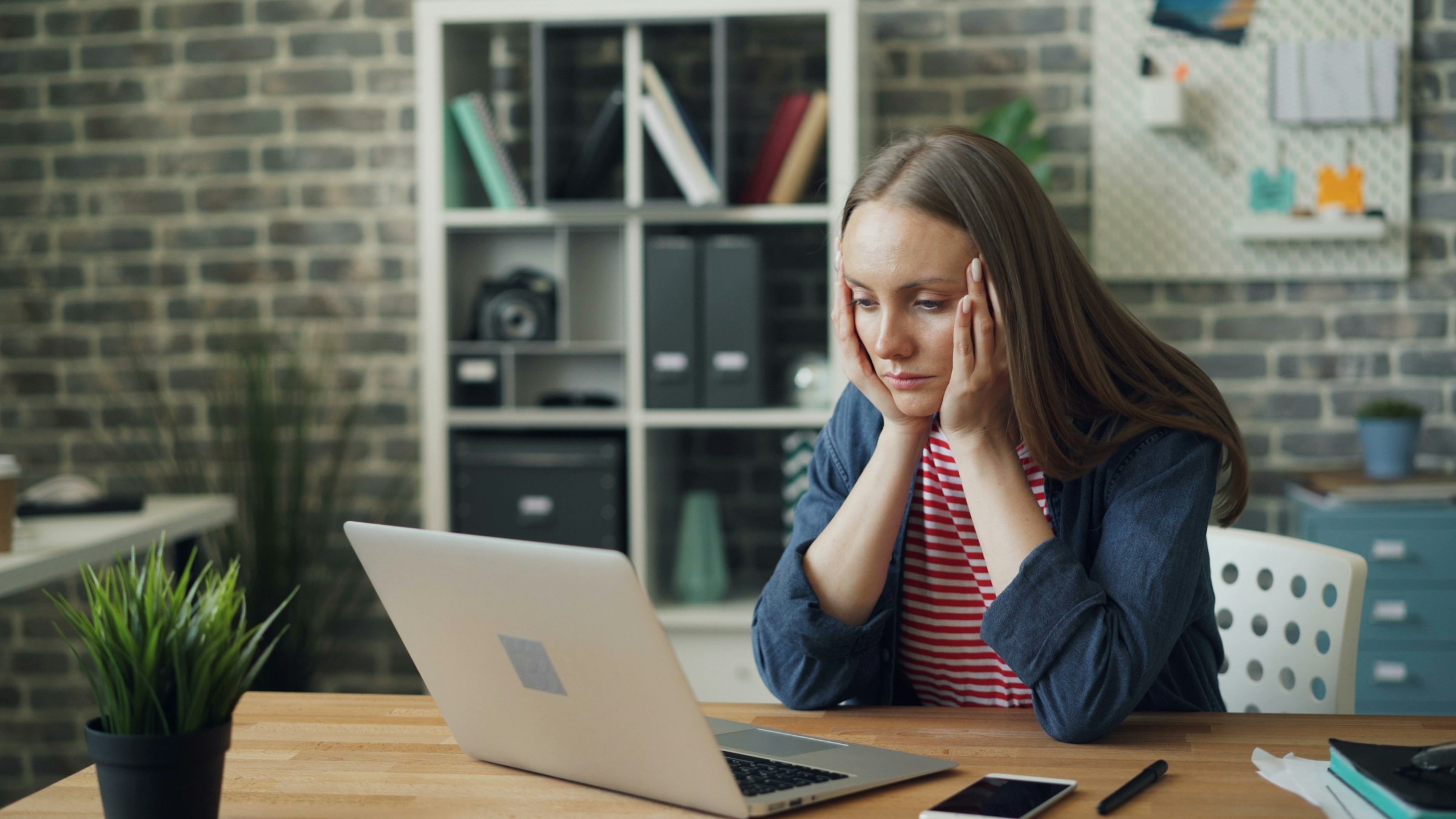 tired woman looking at laptop